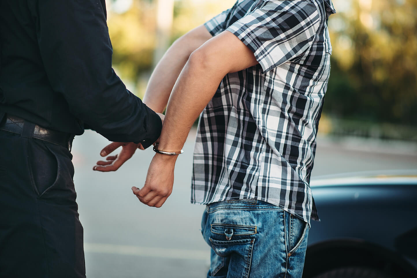 a police officer places a person under arrest with handcuffs before a home monitoring system can be in place
